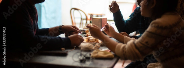 Obraz Silhouette of a group of young friends having lunch in a restaurant in a festive day. Indian lifestyle.