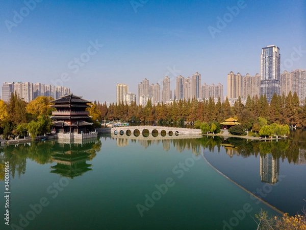 Fototapeta Panoramic view of the lake with a typical chinese temple and the new city above