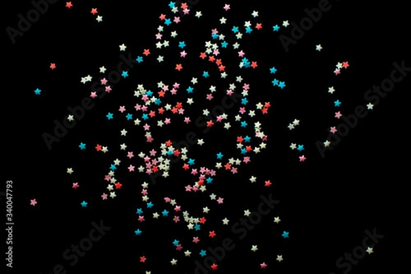 Fototapeta multicolored confectionery sprinkle in the form of stars on a black background