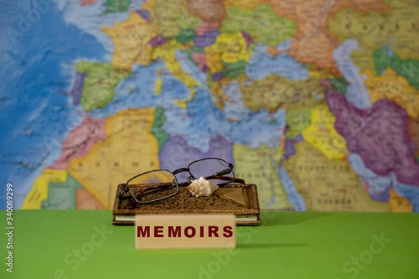 Fototapeta Notebook with memories of the traveler against the background of the map of the world. Vision glasses and a souvenir in the form of a sea sink.