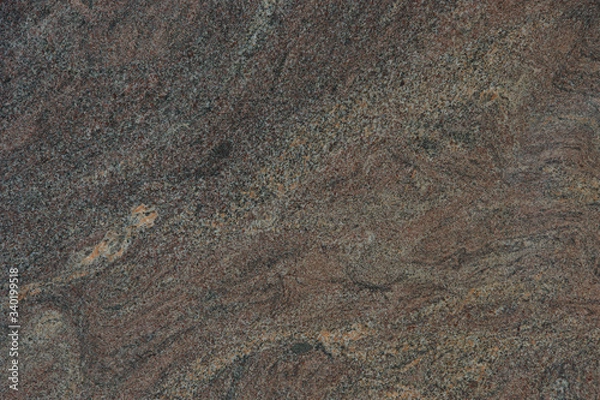 Fototapeta Background from a beautiful natural stone of maroon color with a wavy pattern is called granite Paradiso Classico