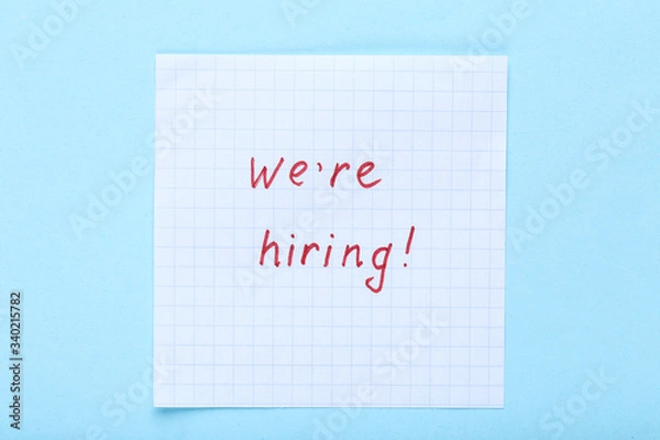 Obraz Text We Are Hiring on paper on blue background