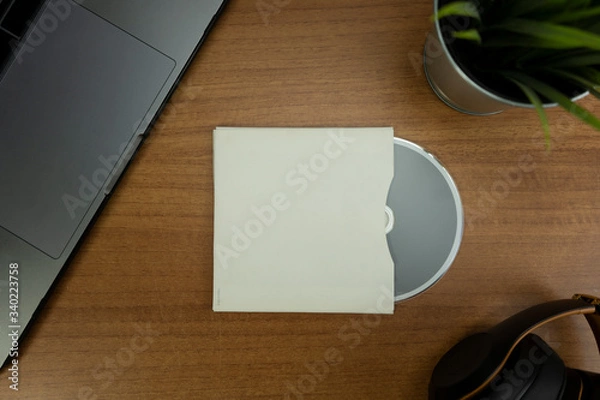 Fototapeta Empty CD and CD case in a wood background with objects for mockup purposes