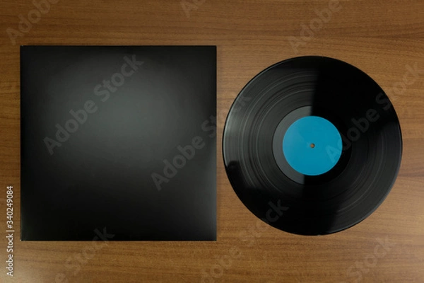 Obraz Empty Black Vinyl disk case and vinyl with blue tag in a wood background for mockup purposes