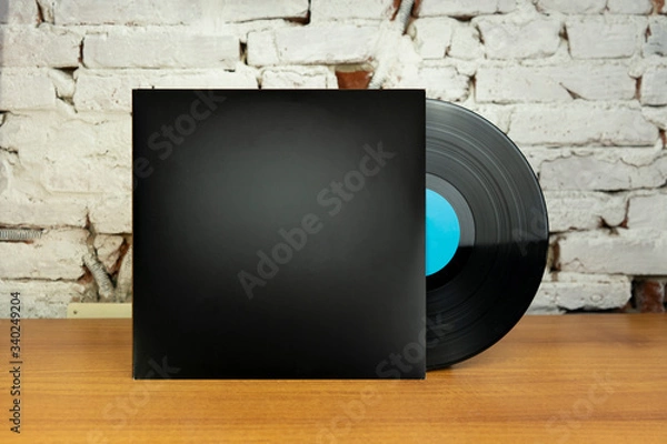 Obraz Empty Black Vinyl disk case and vinyl with blue tag in a wood table and white wall for mockup purposes