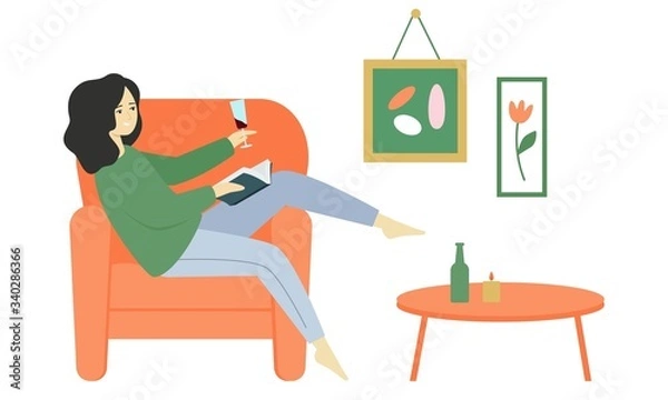 Fototapeta A girl sits in an armchair, reads a book and drinks wine from a glass.