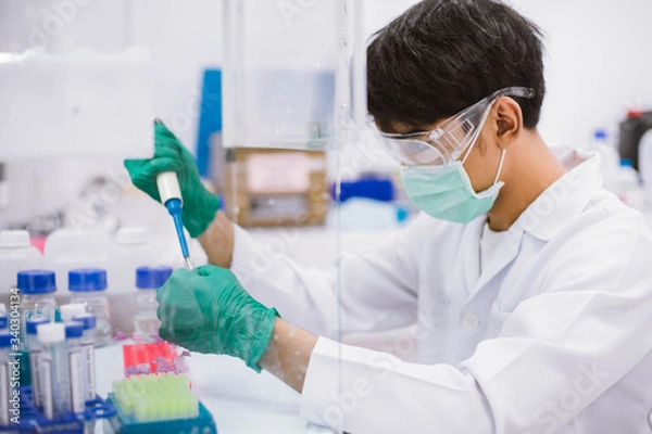 Fototapeta Young scientist using pipette transfer sample to Micro Centrifuge Tube for PCR test in Biosafety cabinet.