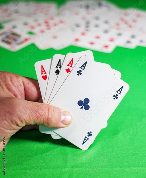 Obraz man plays cards on the green table - poker of aces in the player's hand