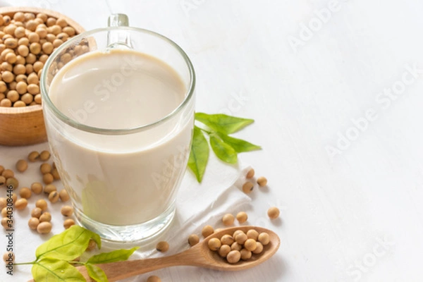 Obraz Soy or soya milk in a glass with soybeans in wooden bowl background