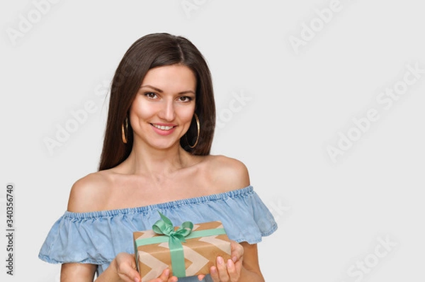 Obraz Beautiful smiling sexy woman holds beautiful a gift box in her hands.