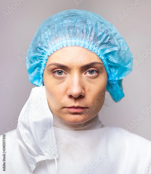 Obraz portrait of doctor woman in medical uniform looking seriously at camera