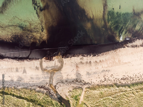 Fototapeta Aerial drone shot of polluted beach in Scotland with chemical pollution being constantly released. Vertical drone look.