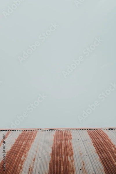 Obraz The roof of a home  on a minimalistic sky background.