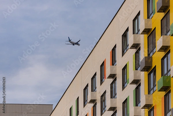 Obraz The plane over the apartment block. Glissada passes over high-rise buildings. Noise from planes prevents sleep