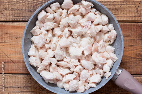 Obraz Step-by-step preparation of chicken fillet with mushrooms in sour cream sauce, step 2 - frying chopped chicken fillet, selective focus