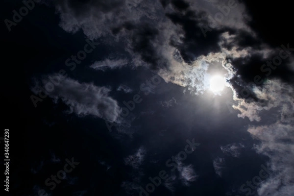 Fototapeta Moon in the night sky among the clouds.