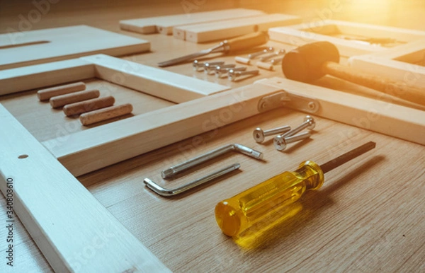 Fototapeta Top view of furniture assembly parts and wood work tools on wooden floor for DIY do it yourself