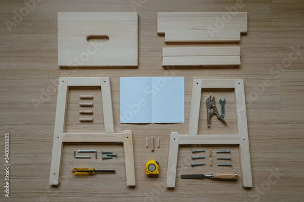 Fototapeta Top view of furniture assembly parts and tools on wooden floor for DIY do it yourself and assemble the work, blank space instruction paper to put logo