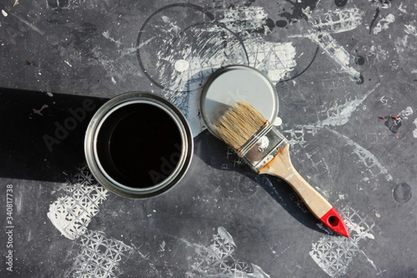 Fototapeta Painters work with brush and can on black floor cover from above