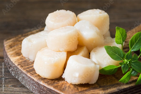 Obraz Scallops on a wooden Board on a brown wooden table. Scallops close up
