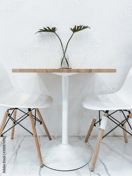 Obraz elegant white chairs and table with Philodendron in glass vase..minimal concept. decorate for cafe and japanese house style.