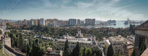 Fototapeta Malaga Spain wide panorama landscape cityscape and view of the port, the sea, the bullring and the town skyline on a sunny day with clouds in the sky from the Alcazaba Fortress.