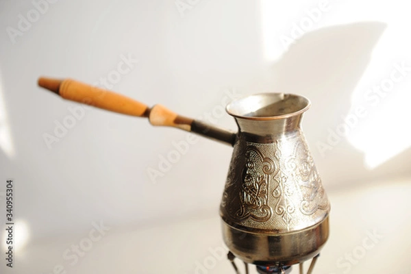 Fototapeta Cezve coffee brewing on gas-burner. White background