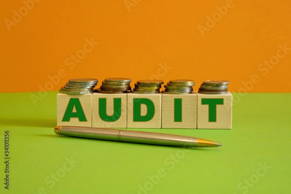 Fototapeta A metal handle and rows of coin stacks with toy wooden blocks symbolizing a financial audit. Space for additional text.