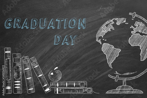 Fototapeta Lettering GRADUATION DAY, rotating globe and school books are drawn with chalk on a blackboard