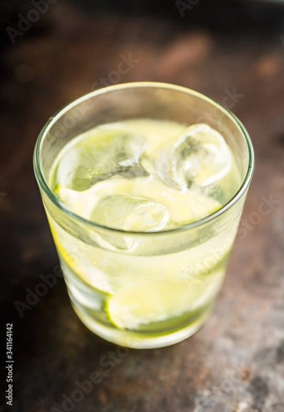Fototapeta Rum based cocktail caipirinha (variation of cuba libre) on the rustic background. Selective focus. Shallow depth of field.
