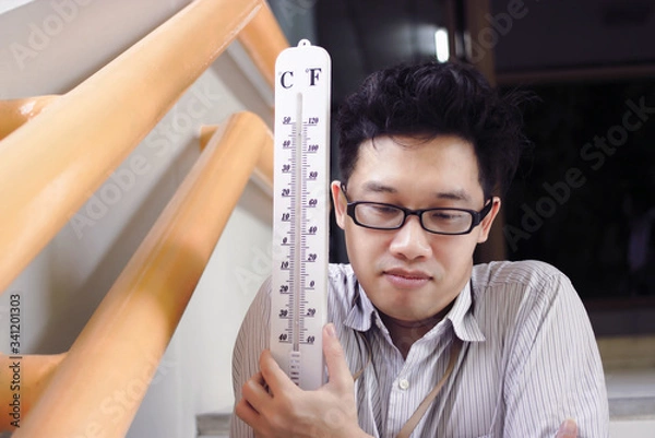Fototapeta Sick and tired Asian man with thermometer suffering cold and flu virus.