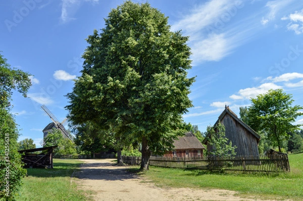 Obraz Krajobraz wiejski. Skansen, Zagroda wiejska z wiatrakiem.