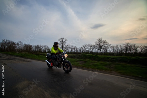 Obraz man rides a motorcycle on a highway