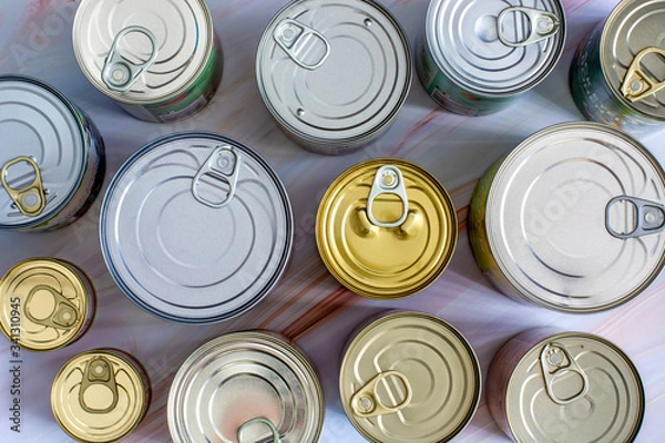 Fototapeta Overhead view various closed tin cans with food preserves. Canned food in different sizes and colors. Stock non-perishable preserved food