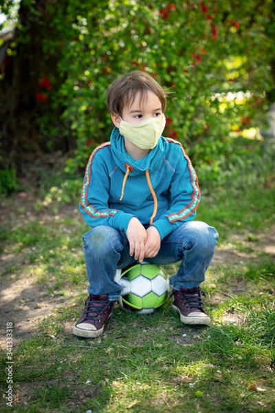 Obraz Child with face mask is playing with a ball