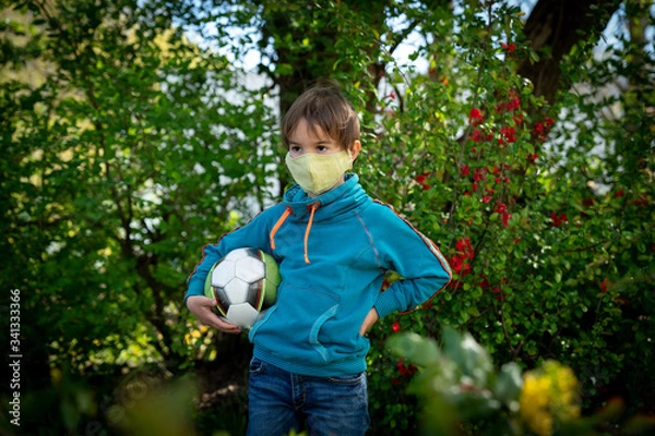 Obraz Child with face mask is playing with a ball