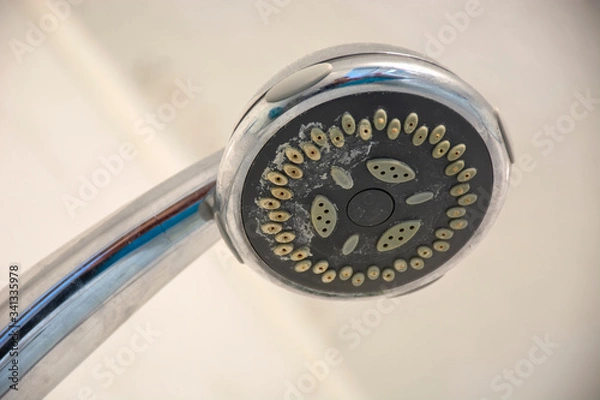 Fototapeta Dirty chrome shower head with limescale that should be cleaned. Calcified shower due to hard water. Calcium mineral buildup.