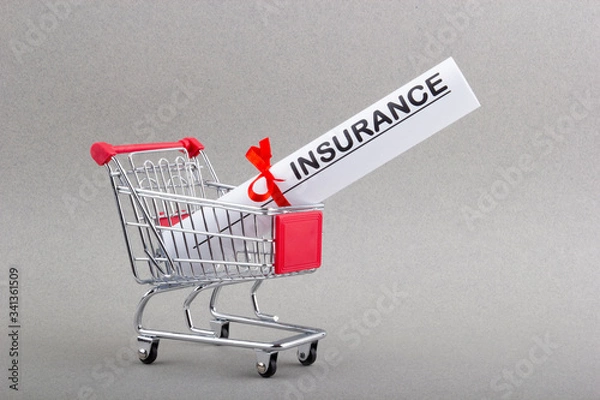 Obraz Paper bundle with word insurance and red ribbon in shopping trolley.