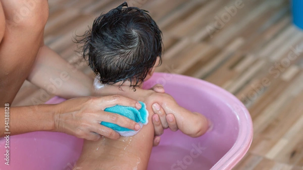 Fototapeta Asian new born having a bath by mother