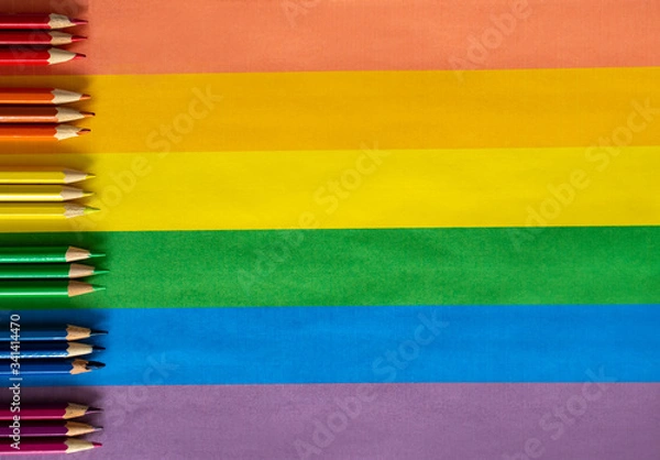 Fototapeta Colored pencils lie on colored paper in the form of a rainbow in the color of the LGBT flag