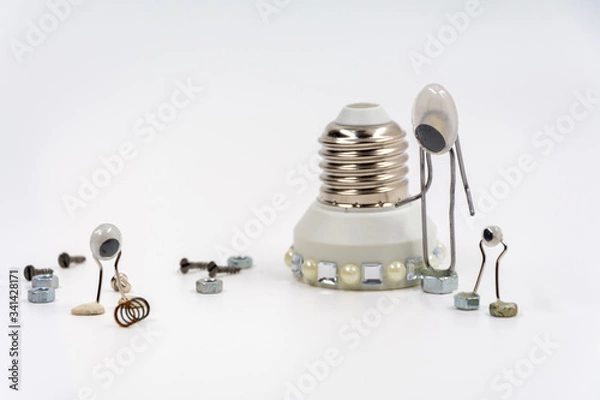 Fototapeta creative idea. 3 metal clips with eyes depicting aliens repairing a flying saucer. white background. empty space.