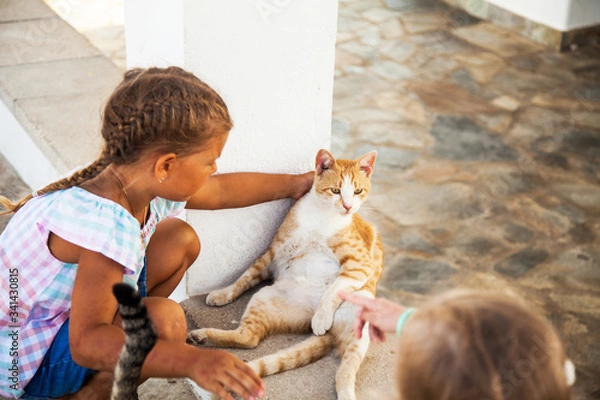 Obraz Little girl playing with cat
