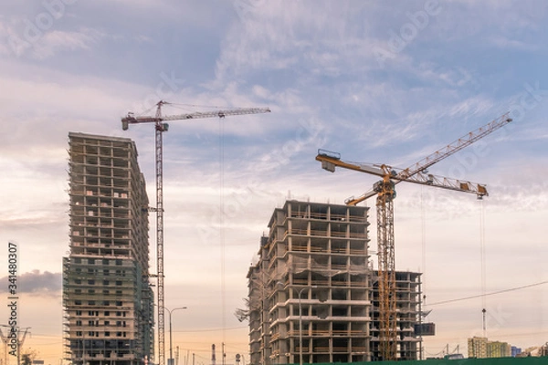 Fototapeta Construction site for residential complex with 3 tower cranes. Selective focus.