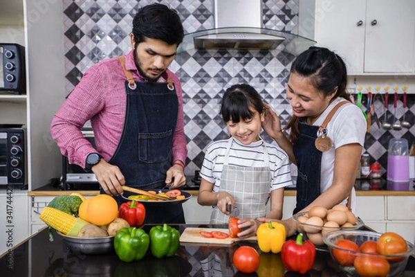 Fototapeta Asian families are cooking  and parents are teaching their daughters to cook in the kitchen at home. .Family activities on holidays and Happy in recreation concept
