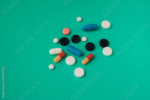 Fototapeta multi colored pills on green background