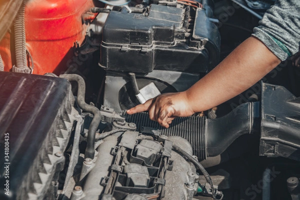 Fototapeta Little child trying to fix broken real car. Dreaming to be auto technician. Close up under the hood of a car