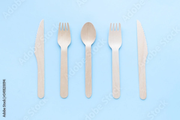 Fototapeta eco friendly disposable kitchenware utensils on blue background. wooden forks and spoons. ecology, zero waste concept. top view. flat lay.