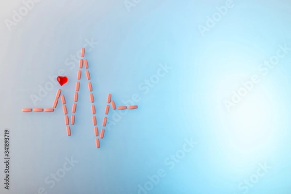 Obraz Pills in shape of cardiogram pulse on blue gradient background. Vitamins and red glass heart, symbol of healthy lifestyle. Pharmaceutical and cardiology concept. Heartbeat rhythm made of tablets