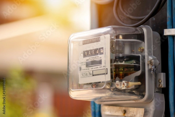 Fototapeta Electricity meters for home electrical appliances, including blurred natural green backgrounds, electric power usage concepts, and electricity usage audits