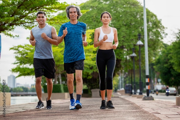 Fototapeta Family exercising and jogging together in the outdoor garden. Healthy family